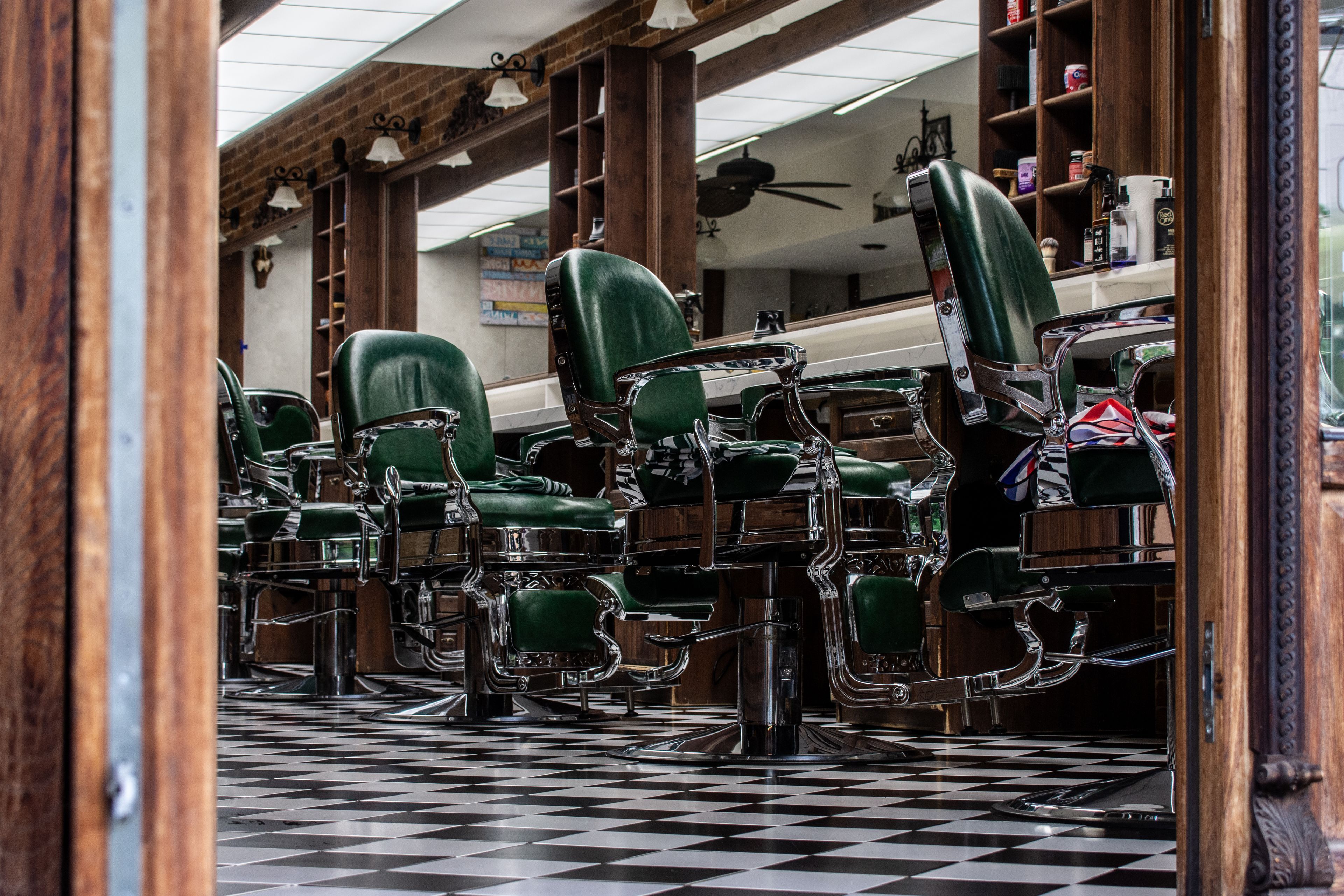 The shop's green barber chairs on a checkered floor
