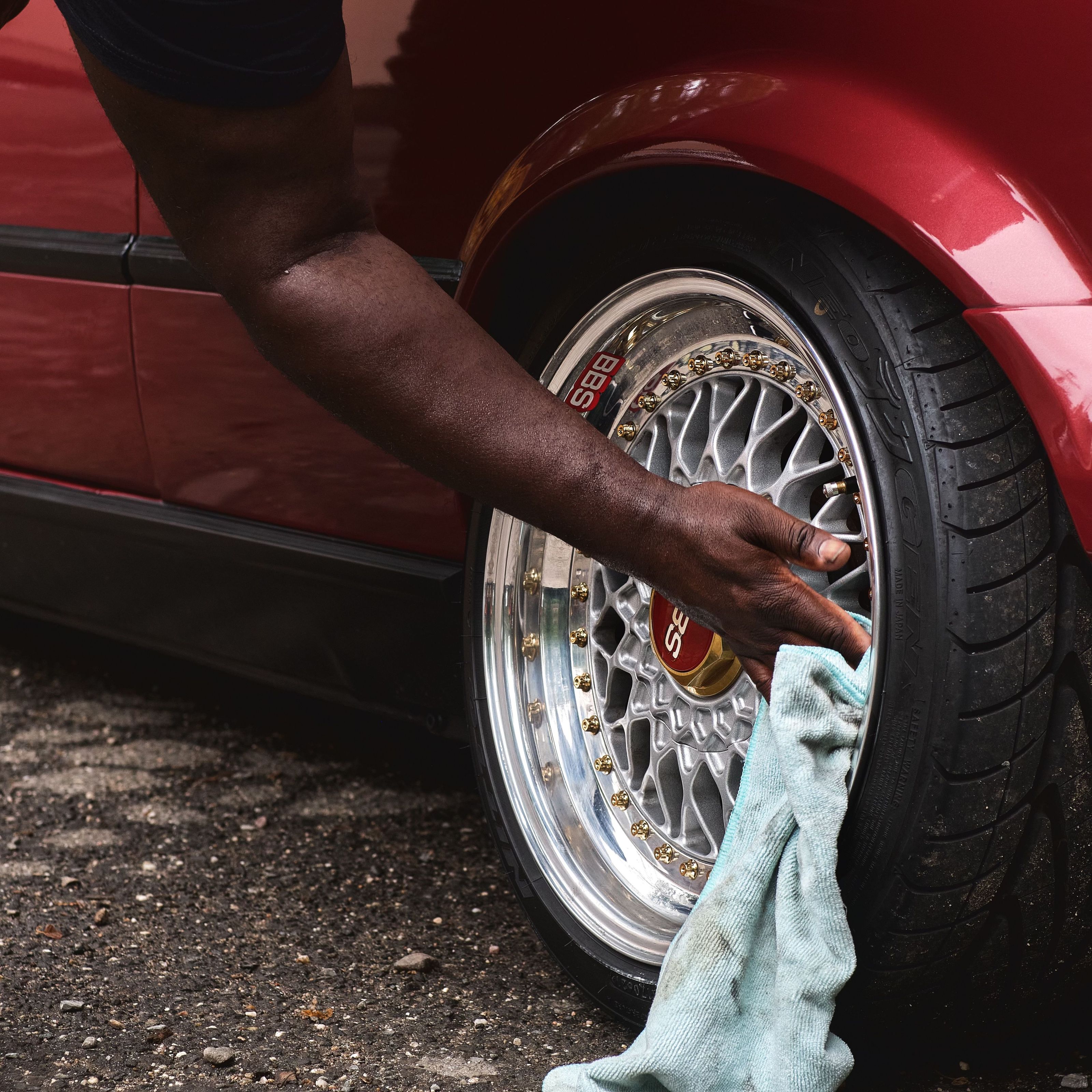 A detailer wiping down a polished wheel
