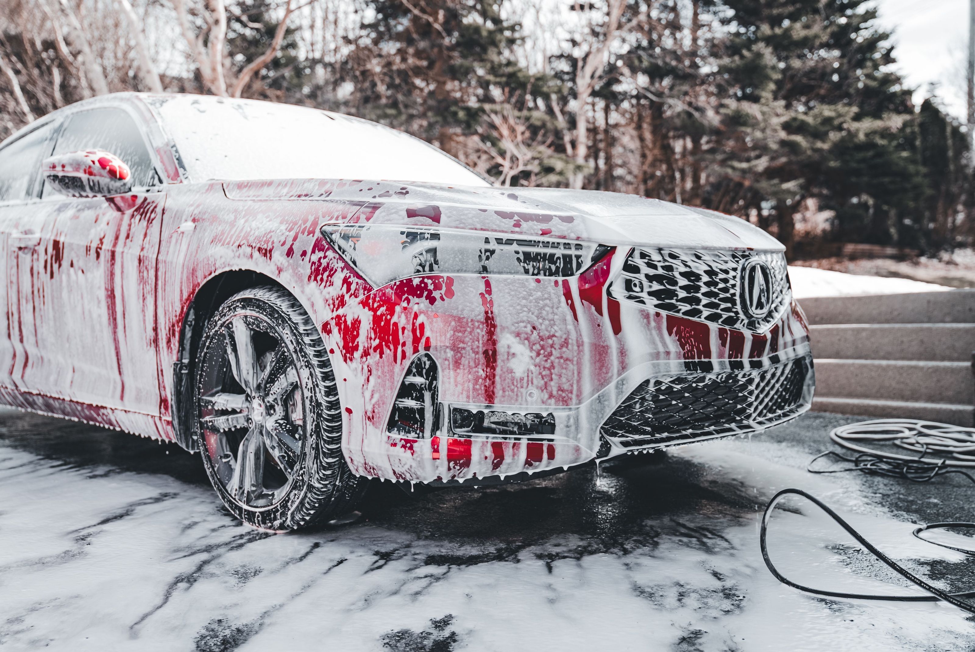 A car covered in snow foam during a wash