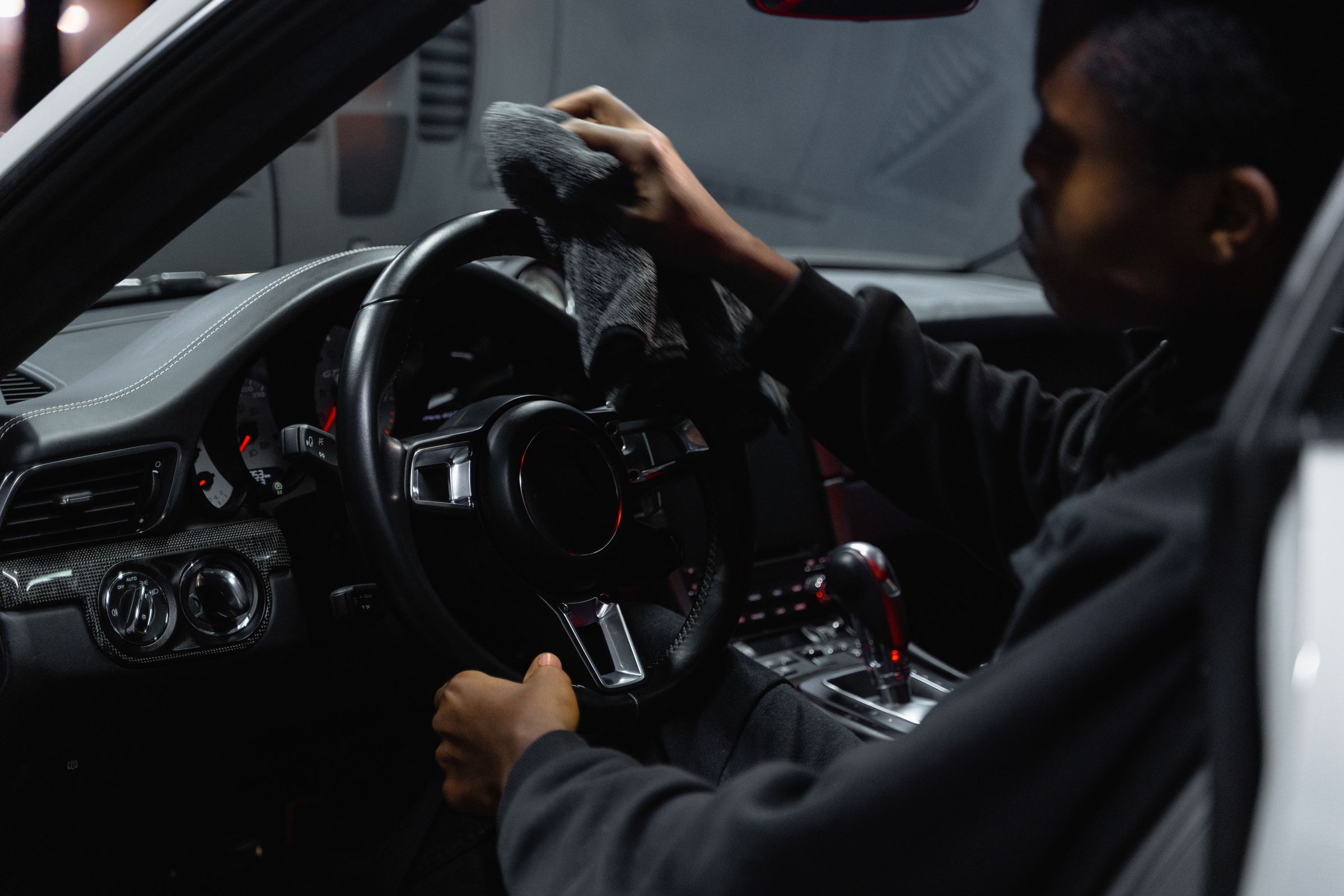 A detailer wiping down a steering wheel