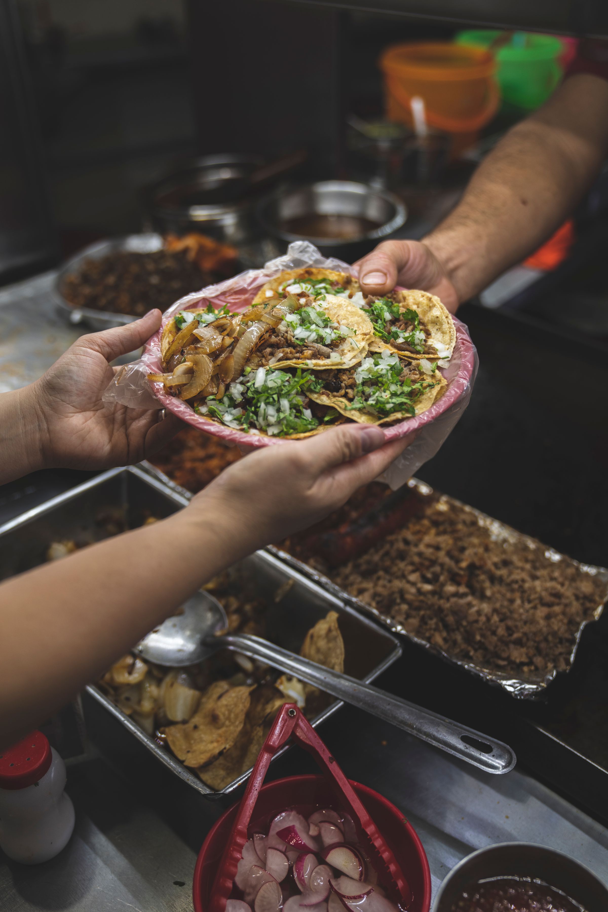 A plate of tacos passed across the counter
